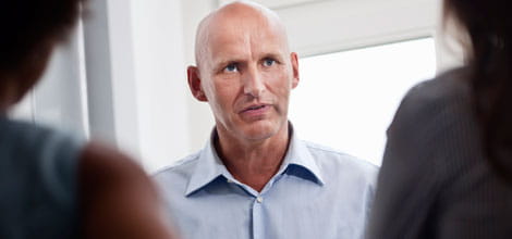 man confronted by two colleagues